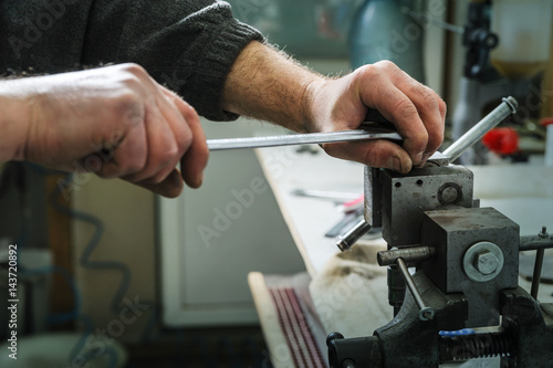 Mechanics repairing a diesel injector. © yunava1