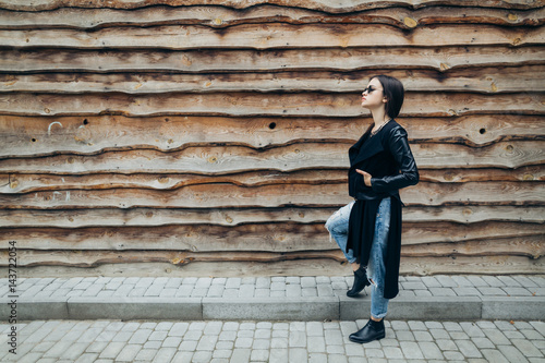 Fashionable model in sunglasses posing at the wooden wall. © anatoliycherkas