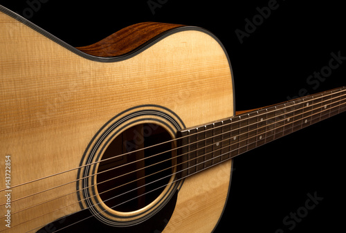 Yellow acoustic wooden guitar on a black background