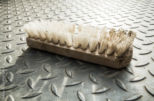 Fotografie Dirty scrubbing brush on a metal grid