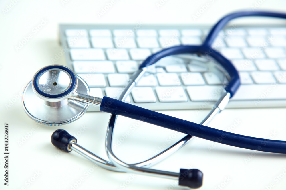 medical stethoscope near laptop on white wooden table medical stethoscope near laptop on white wooden table