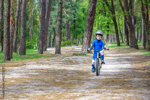 Wallpaper Mural Happy cute blond kid boy having fun his first bike on sunny summer day, outdoors. Happy child making sports. Active leisure for children.Kid boy wear safety helmet. boy is smiling and cicling. Torontodigital.ca