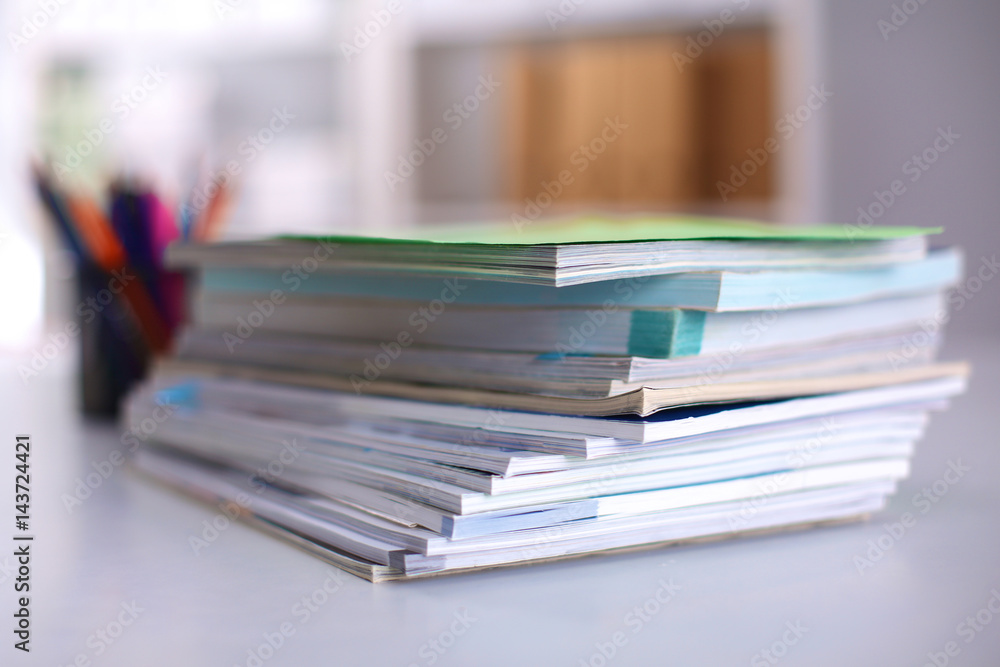 A stack of documentation is on the desktop in the office A stack of documentation is on the desktop in the office