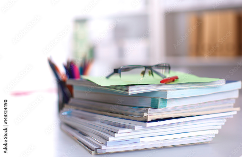 A stack of documentation is on the desktop in the office A stack of documentation is on the desktop in the office