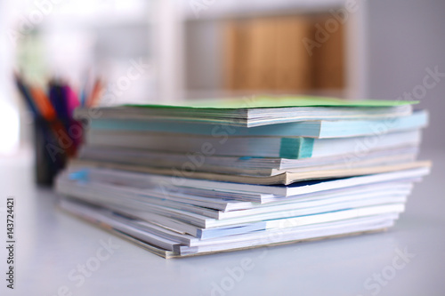A stack of documentation is on the desktop in the office © lenetsnikolai