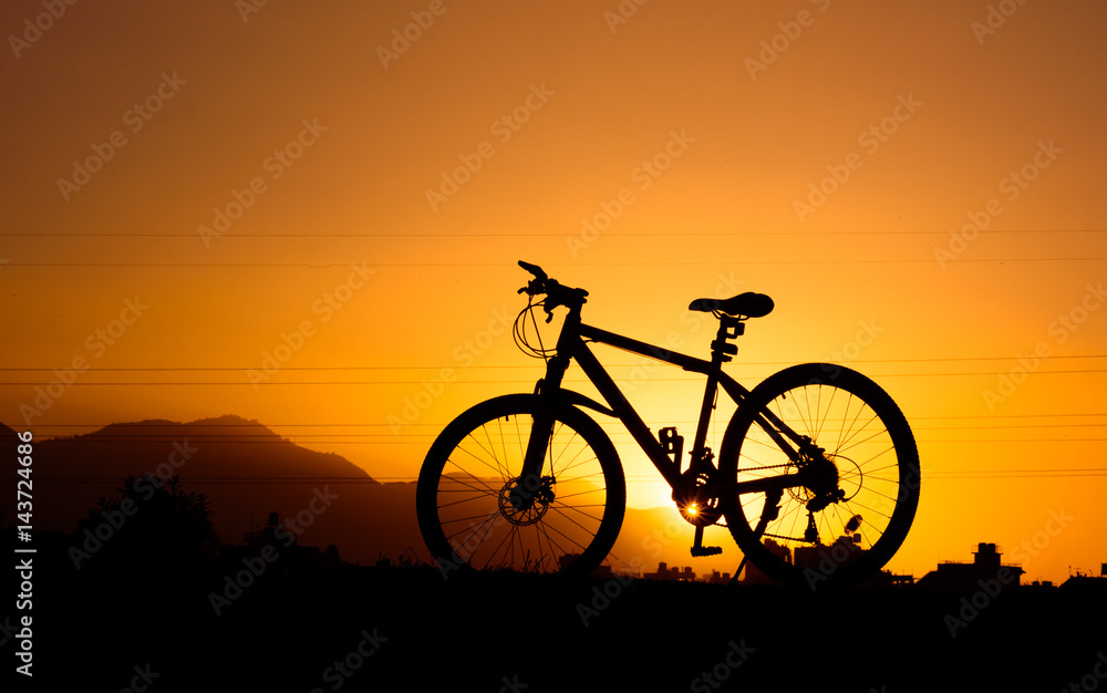Fototapeta premium silhouette of parked bicycle on warm tone with some copy space