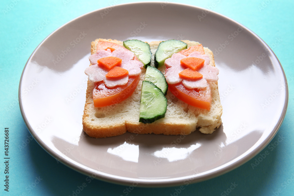 Plate with funny sandwich on color background