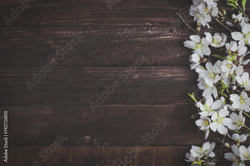 Flowering almond branches on a brown wooden surface