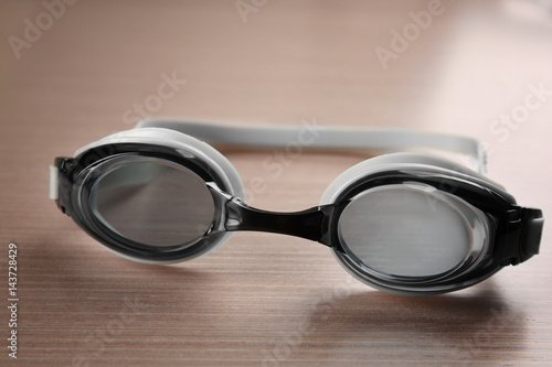 Swimming goggles on wooden background