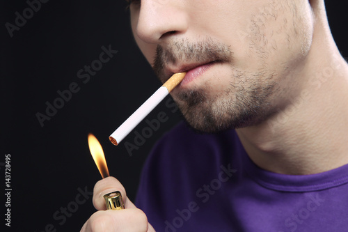 Young man smoking cigarette, closeup