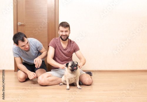 Happy gay couple sitting on...