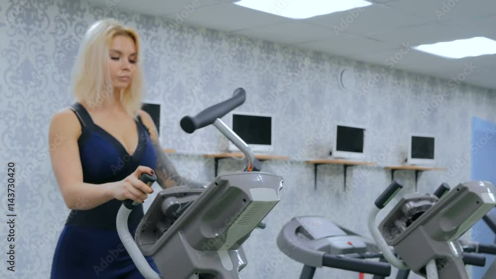 Athletic young woman working out on stepper machine at the gym, fitness club. Close up shot of woman's legs. Health, sport and cardio workout concept Athletic young woman working out on stepper machine at the gym, fitness club. Close up shot of woman's legs. Health, sport and cardio workout concept