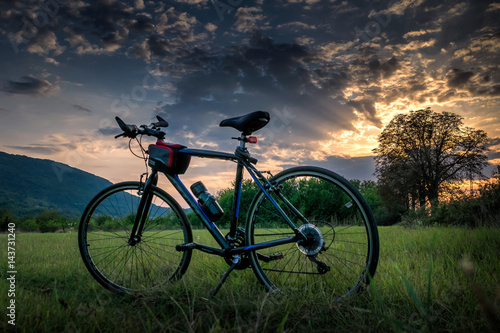 Fototapeta Naklejka Na Ścianę i Meble -  Recreation with bicycle at sunset and with dramatic sky
