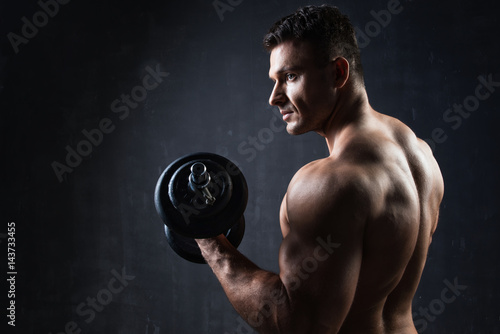 Handsome muscular bodybuilder showing his muscles.