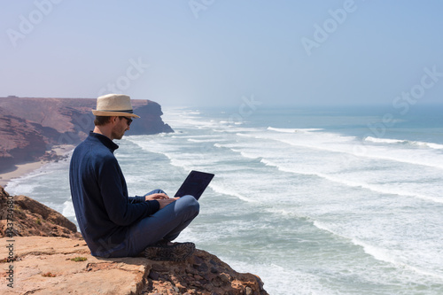 Travailler sur son ordinateur en vacances à la mer
