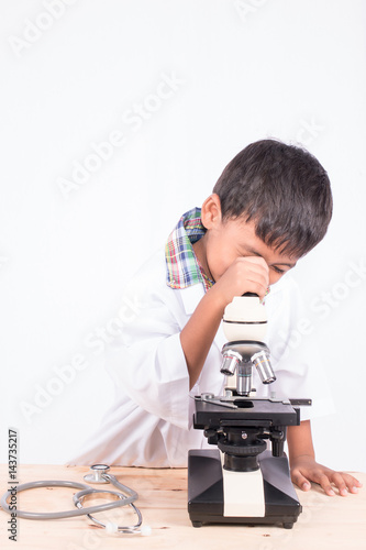 cute asian little student boy working with microscope