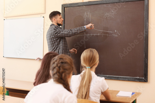 Pupils listening teacher in...