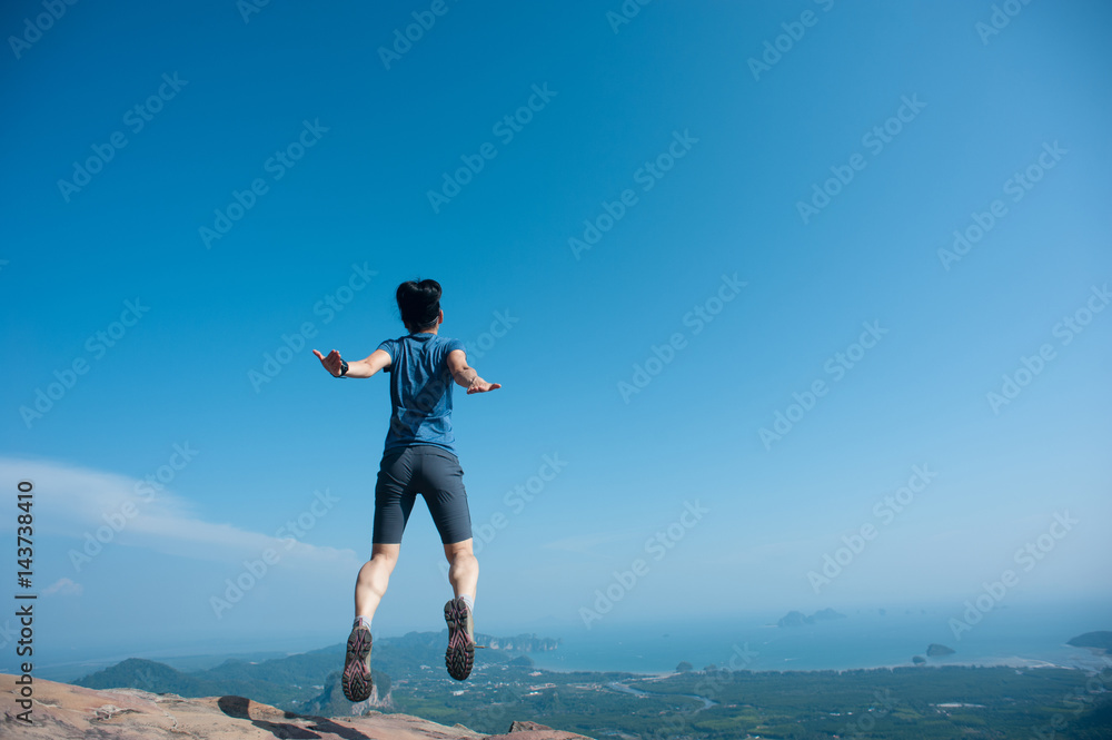jumping on rocky mountain peak, freedom, risk, challenge, success concept jumping on rocky mountain peak, freedom, risk, challenge, success concept