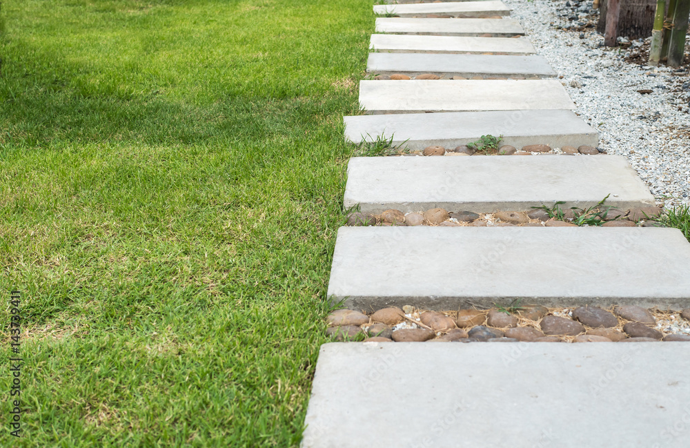 Landscaping in the green garden. pathway in park, with stone tile on green grass field Landscaping in the green garden. pathway in park, with stone tile on green grass field