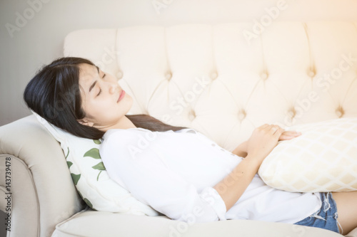 Beautiful Asian women wear white shirt sleeping on sofa