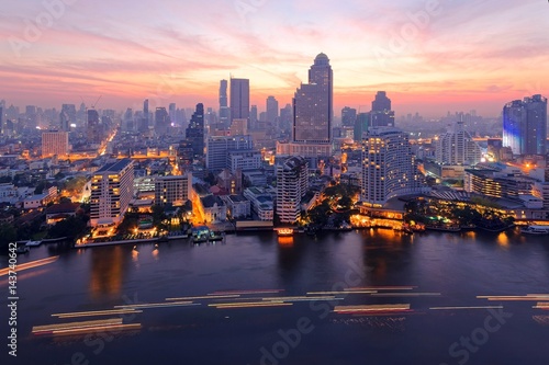 Sunrise scenery of Bangkok City in bird's eye view~ Aerial panorama of Bangkok in morning twilight, with rosy clouds in the sky, light trails on Chao Phraya River & modern skyscrapers by the riverside © AaronPlayStation