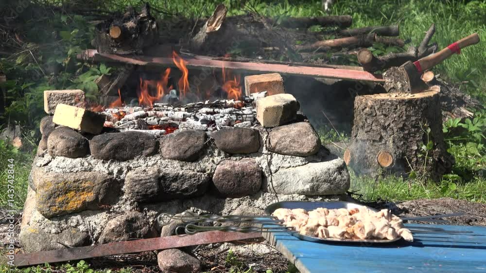 Pork meat on spits and bonfire fire flames in garden fireplace. 4K Pork meat on spits and bonfire fire flames in garden fireplace. 4K