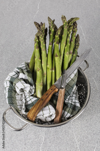 zubereitung grüner spargel mit altem holtz schneidebrett und petersilie photo