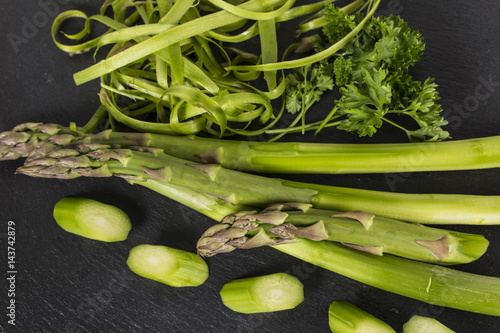 zubereitung grüner spargel mit altem holtz schneidebrett und petersilie photo