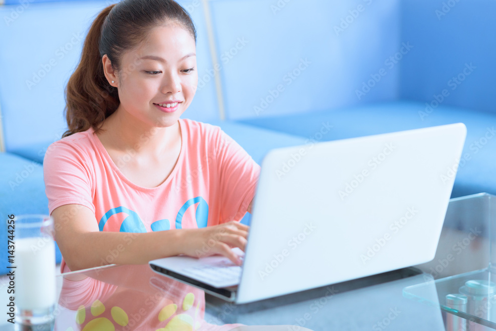 Asian Chinese young woman using laptop in home. Asian Chinese young woman using laptop in home.