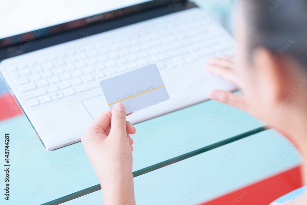 Young woman using credit card with laptop. Young woman using credit card with laptop.