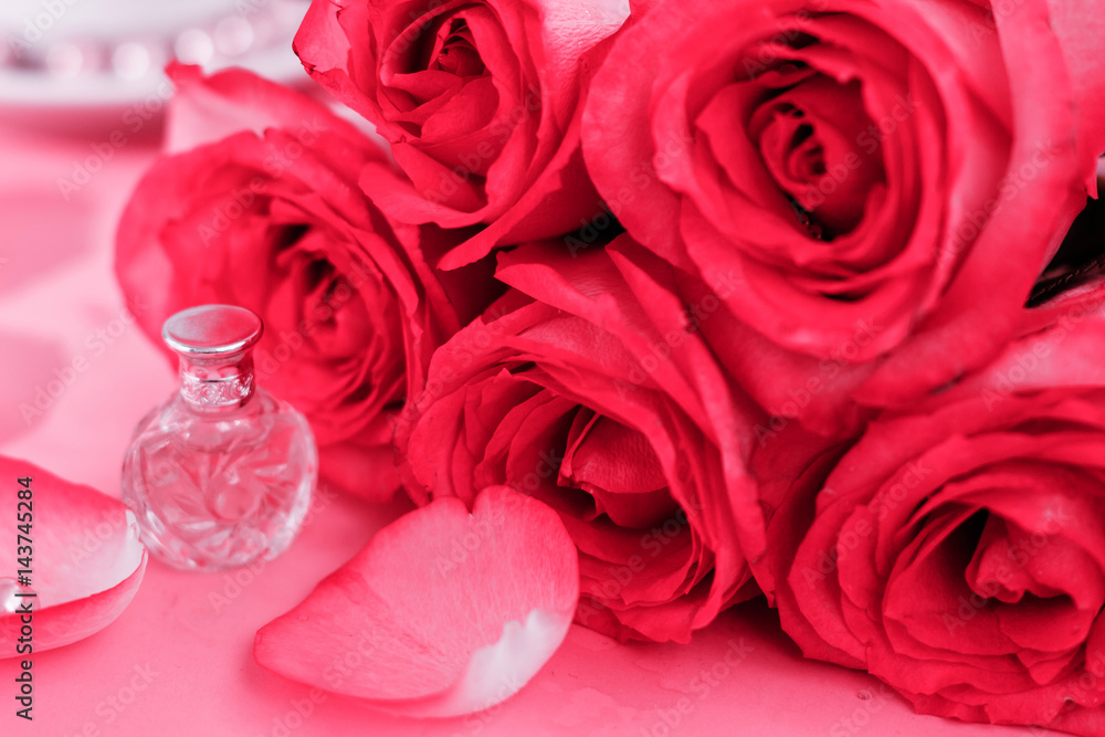 Perfume on a background of pink roses selective focus Perfume on a background of pink roses selective focus