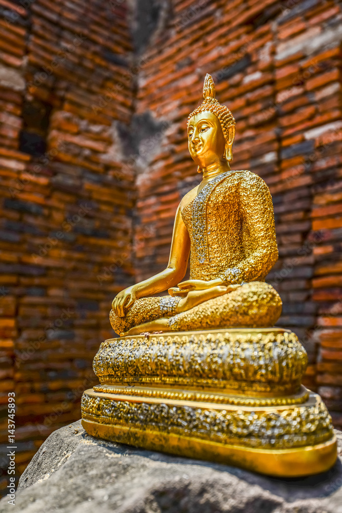 Fototapeta premium Golden Buddha image on rock