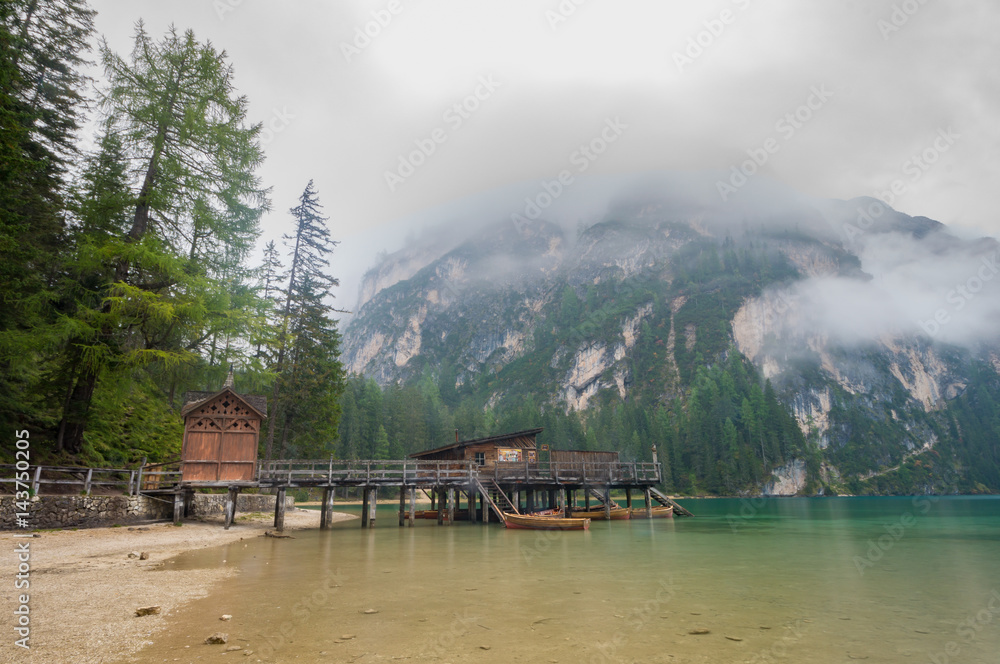 Fototapeta premium Cloudy and foggy morning on the alpine lake Lago di Braies, dolomites, italy