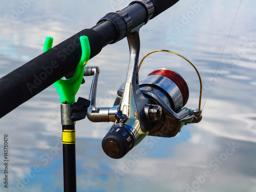 Fishing rod on the stand and coil with the fishing line closeup