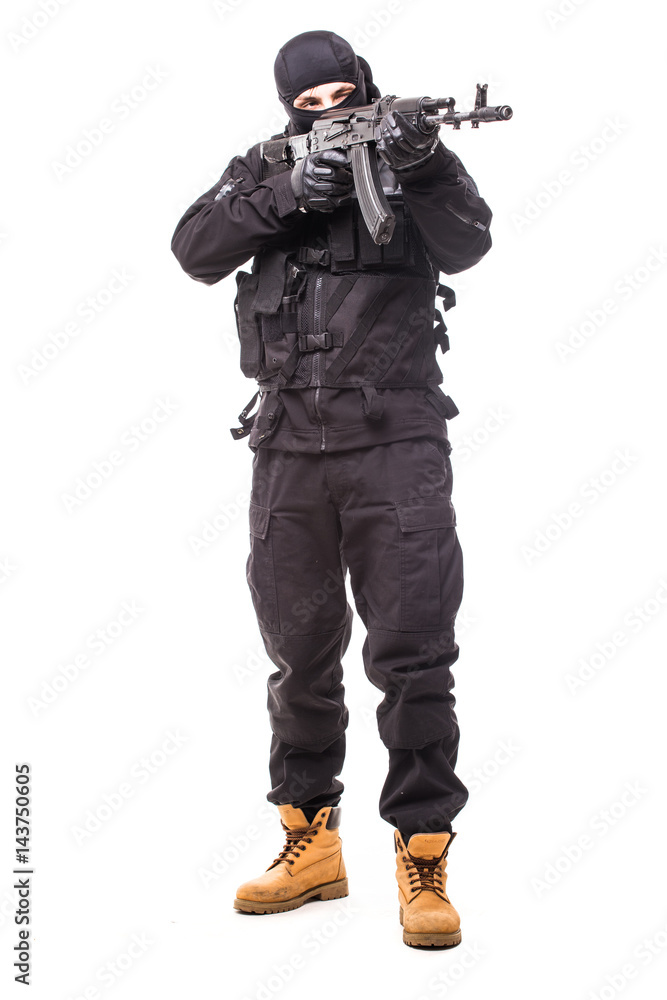 Armed terrorist in black mask and black uniform aiming with a gun. Portrait of good or bad guy Armed terrorist in black mask and black uniform aiming with a gun. Portrait of good or bad guy