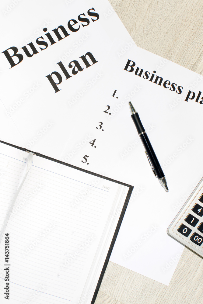 An inscription of the business plan, execution points, there is a notebook and a calculator next to it An inscription of the business plan, execution points, there is a notebook and a calculator next to it