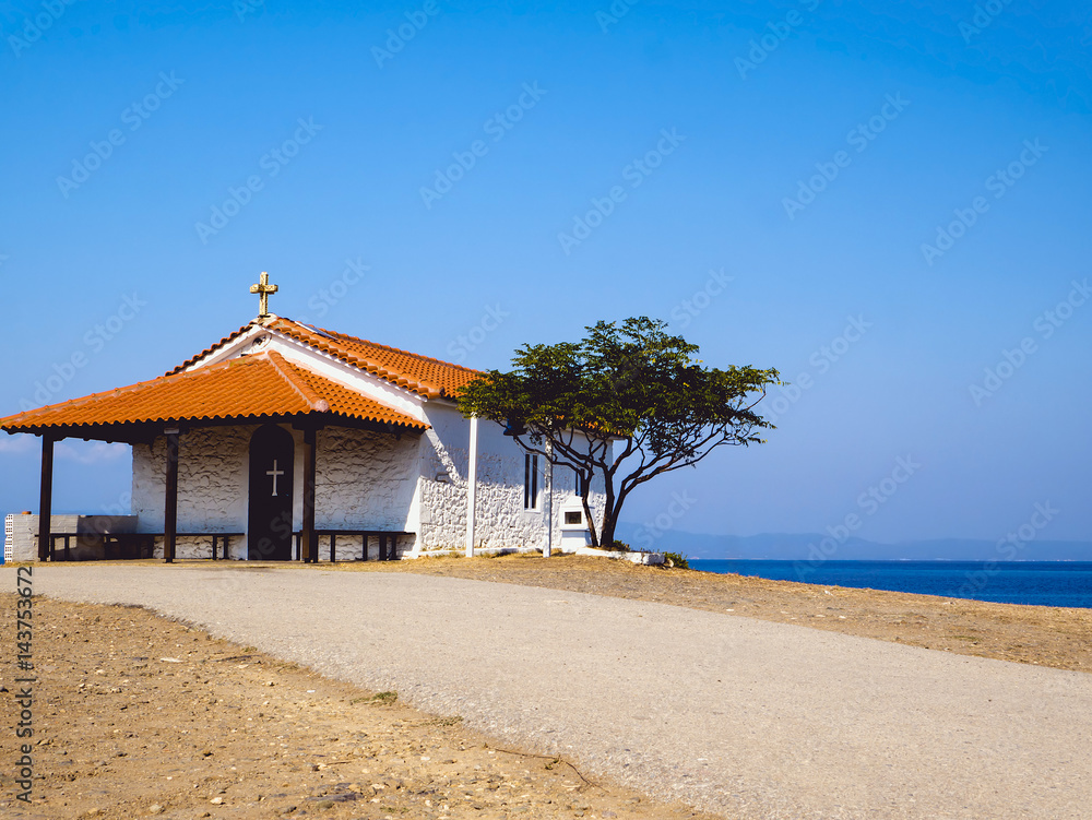 Fototapeta premium Traditional small white church with sea view in Cassandra peninsula,Greece.