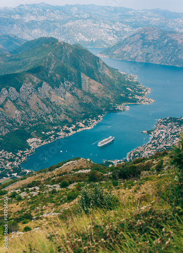 Bay of Kotor from the heights. View from Mount Lovcen to the bay. View down from the observation platform on the mountain Lovcen. Mountains and bay in Montenegro. The liner near the old town of Kotor. © Nadtochiy