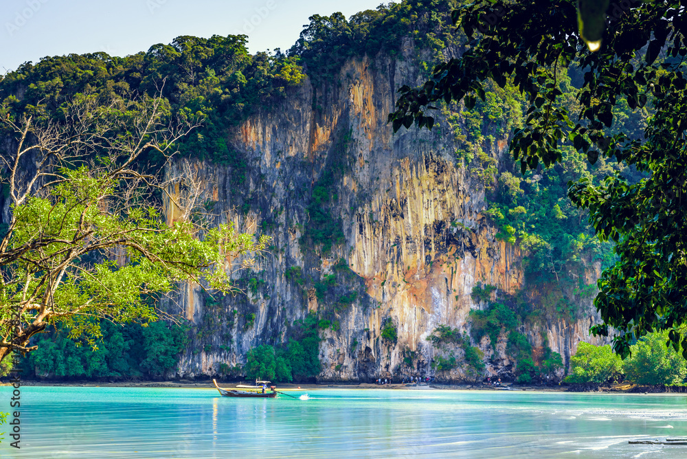 Long tail boat and rocks on East Railay Beach in Krabi, Thailand