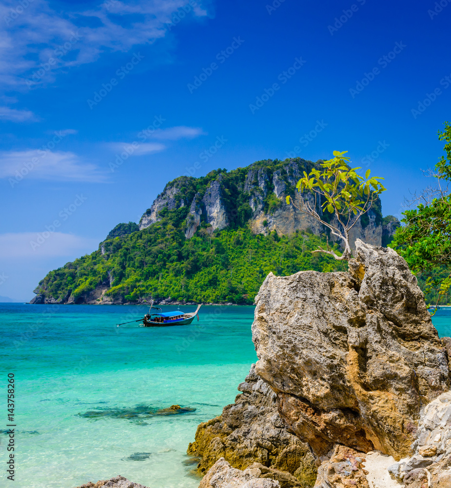 Tropical see with clear turquoise water, rocks, long tail boat and island. Typical thai landscape from Poda Island, West Railay Beach, Krabi, Thailand.