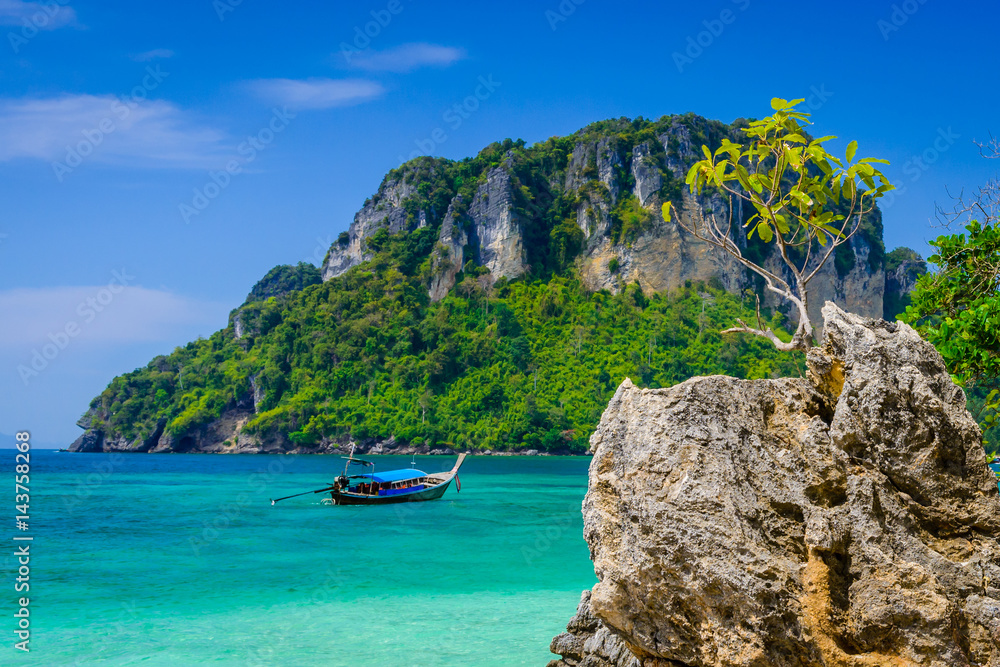 Tropical see with clear turquoise water, rocks, long tail boat and island. Typical thai landscape from Poda Island, West Railay Beach, Krabi, Thailand.