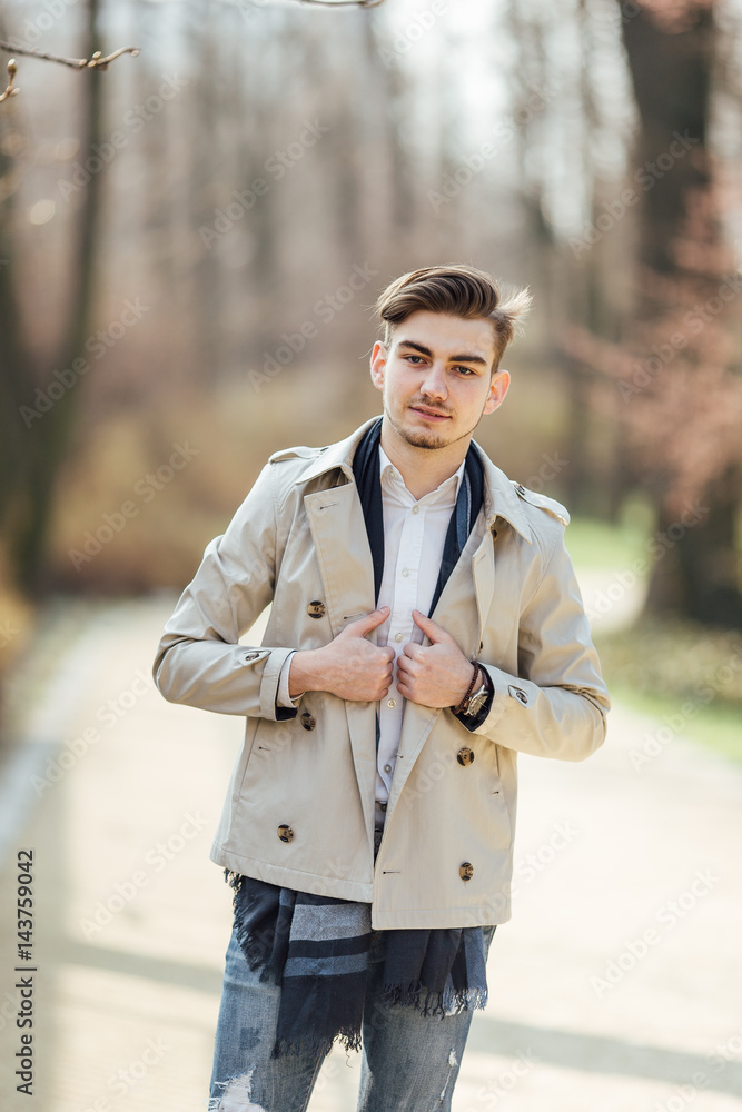 Fashionable man walking on the park with blur background Fashionable man walking on the park with blur background
