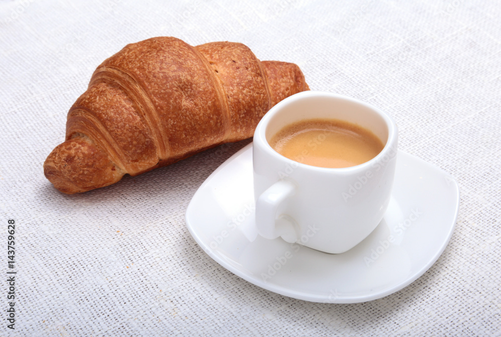 Crispy fresh croissants and cup of coffee espresso on a white background, morning breakfast, selective focus Crispy fresh croissants and cup of coffee espresso on a white background, morning breakfast, selective focus