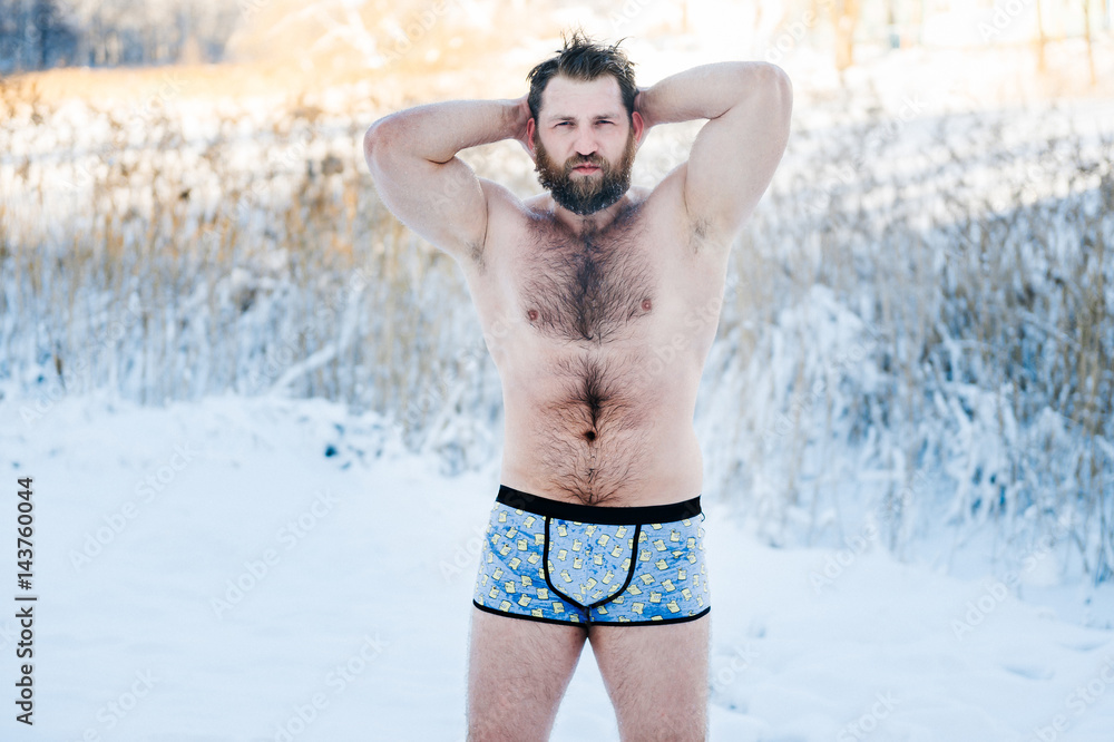 Portrait of russian bearded bodybuilder man with hairy body standing  without clothes outdoors in winter on snow in cold weather after swimming  and posing for camera. Healthy life concept. foto de Stock