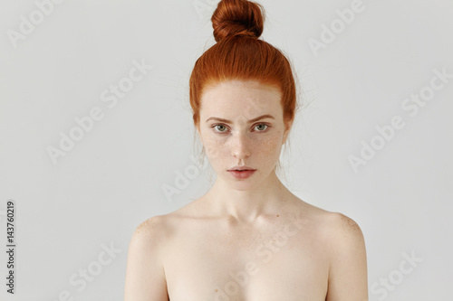 Canvastavla Isolated portrait of beautiful young Caucasian redhead woman with hair bun and p