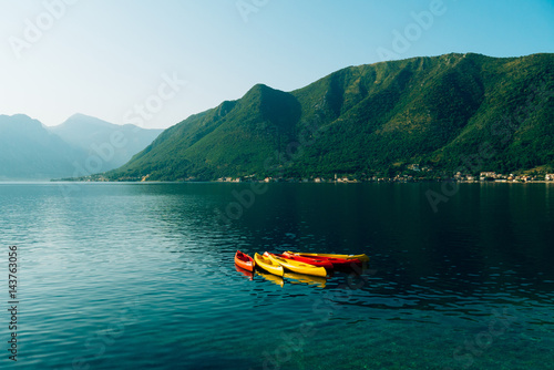 Kayaks moored in the water. Empty kayaks without people. In the Bay of Kotor, in Montenegro. © Nadtochiy