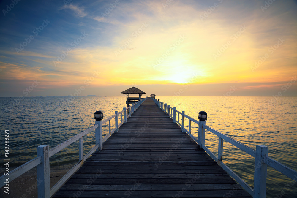 Wooded bridge in the port at sunset.