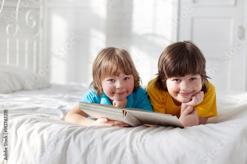 two boy read book indoors