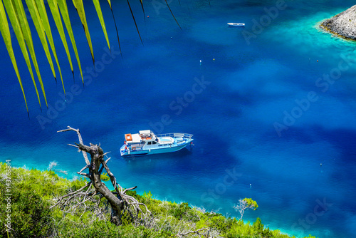 Obraz na płótnie Boat, clear sea water and green palm leaves on tropical sea abstract background. Marine landscape. w salonie