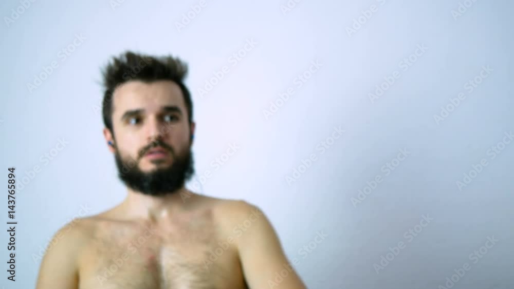 Determined bearded naked man training and showing his strong body, isolated on white background. Determined bearded naked man training and showing his strong body, isolated on white background.